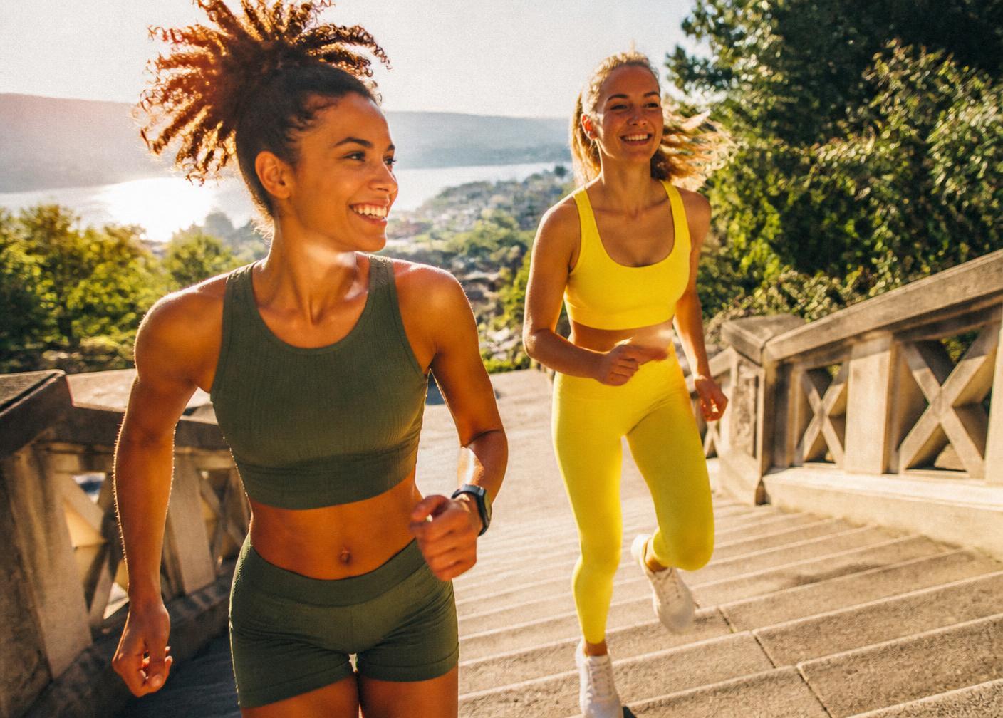 Two runners climbing outdoor stairs in bright morning sunlight